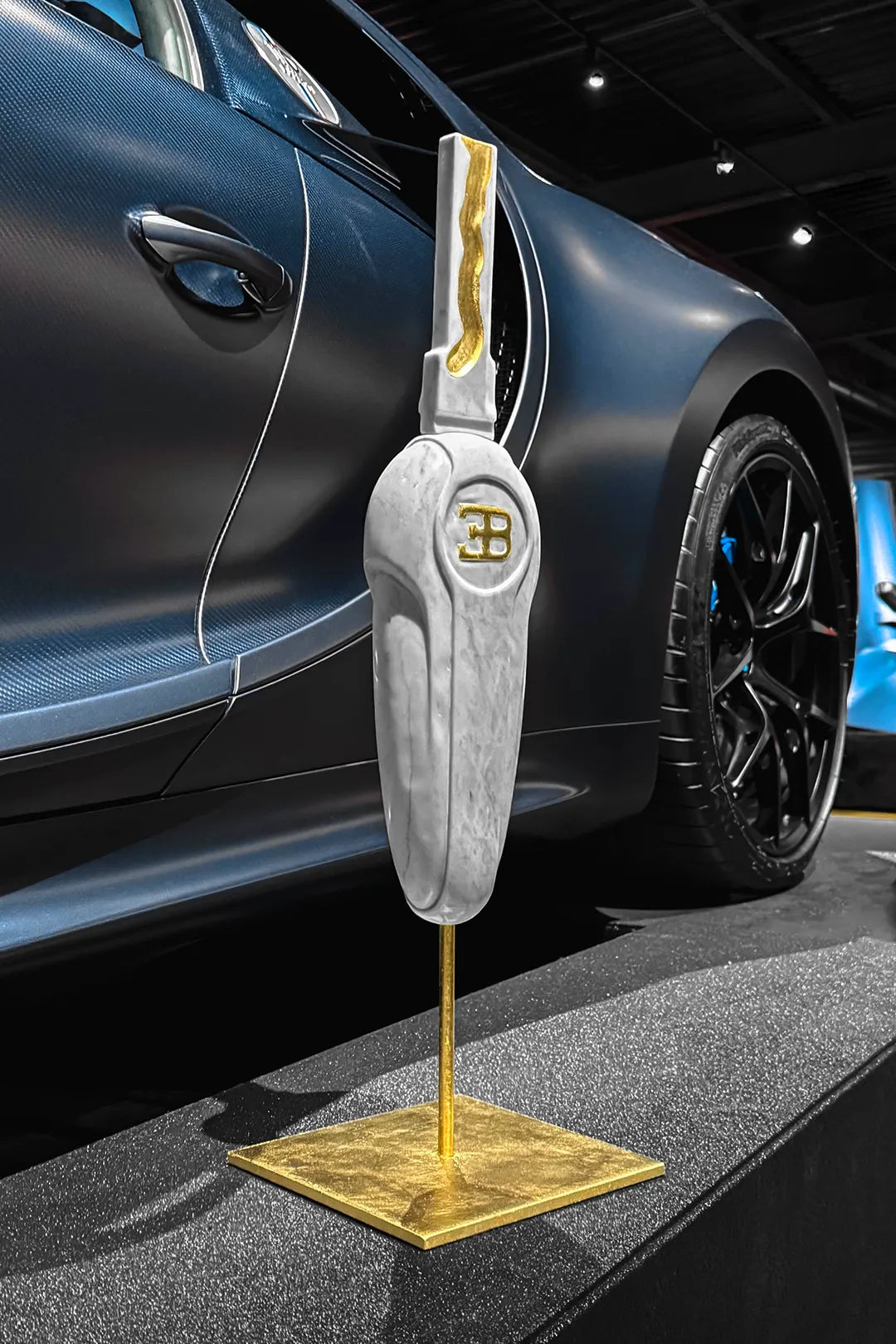 Sculpture Bugatti Veyron en marbre et feuille d’or avec Bugatti Chiron 110 ans